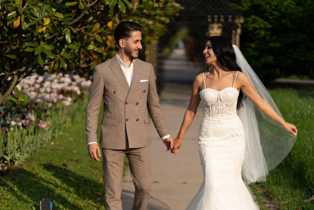 Bride and groom holding hands in a spring garden